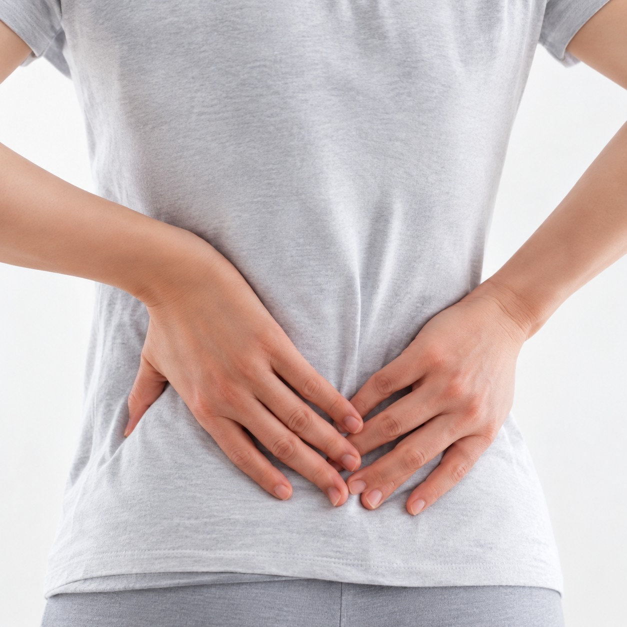 グレーの服の人物が両手で腰を押さえている